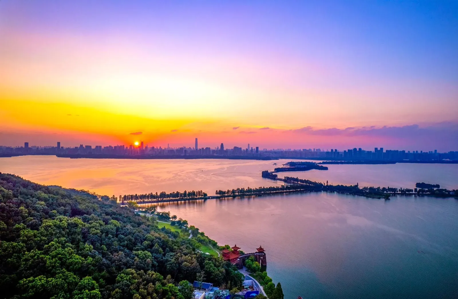 East Lake Wuhan panorama — vast lake surface with islands, causeways, and city skyline in the distance