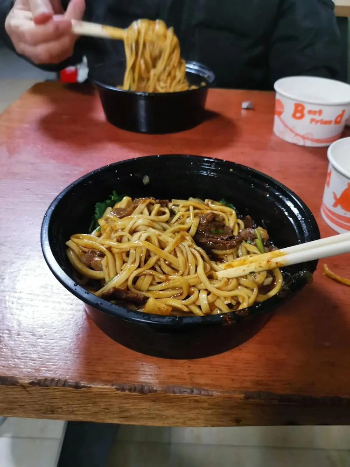 Mixing Wuhan hot dry noodles with chopsticks, sesame paste coating the alkaline noodles