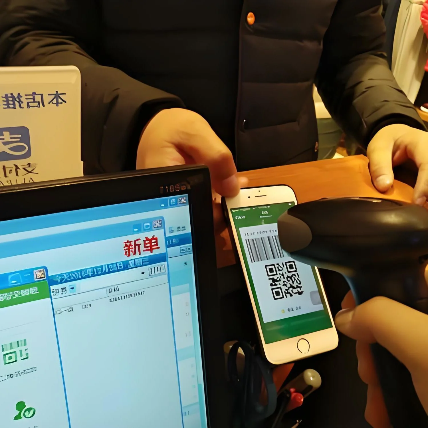 A checkout counter where a phone displaying a QR code is held under a handheld scanner