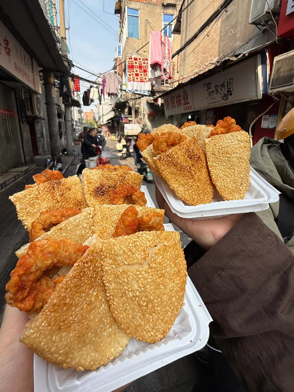 Food stalls near Jianghan Road in Wuhan at night showing steamer baskets and locals eating at outdoor tables