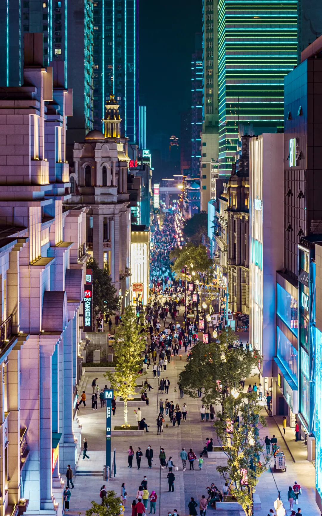 Jianghan Road pedestrian street in Wuhan at dusk with crowds walking between early 20th-century European buildings and modern shopfronts
