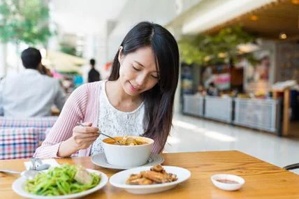 An independent woman eating a meal alone