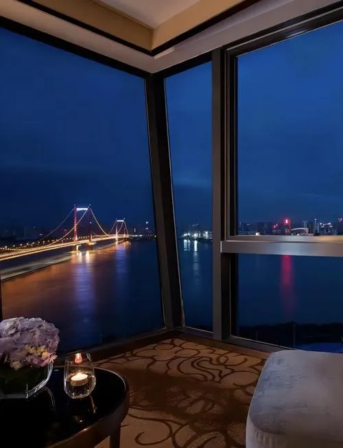 River view from a Hankou Bund hotel room overlooking the Yangtze and Wuchang skyline at dusk