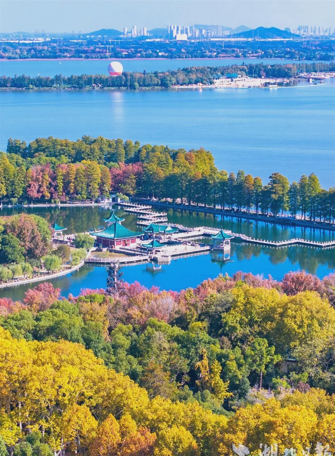 East Lake Wuhan in autumn with red maple trees reflecting on calm water, peaceful lakeside scenery