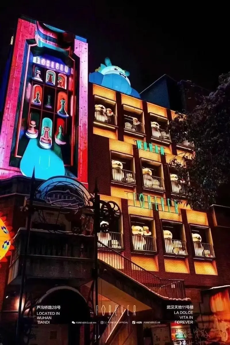 Wuhan nightlife scene with neon lights and crowds on a bar street after dark
