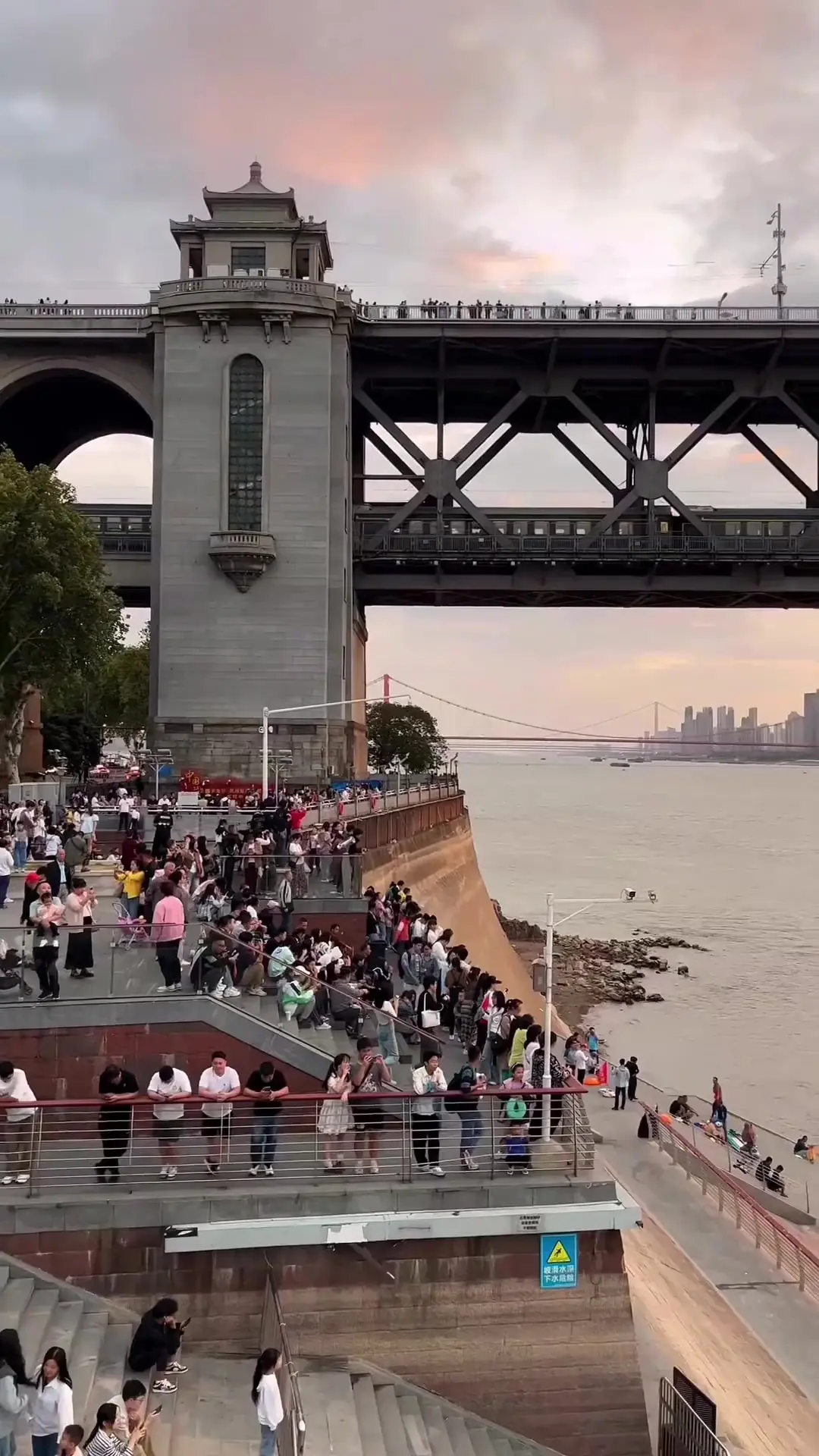 People walking and riding e-bikes across Wuhan Yangtze River Bridge in daily life
