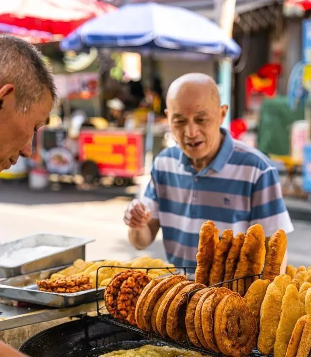 Street scene in Wuhan showing a market vendor and customer talking, capturing the everyday moments where Wuhan dialect is spoken