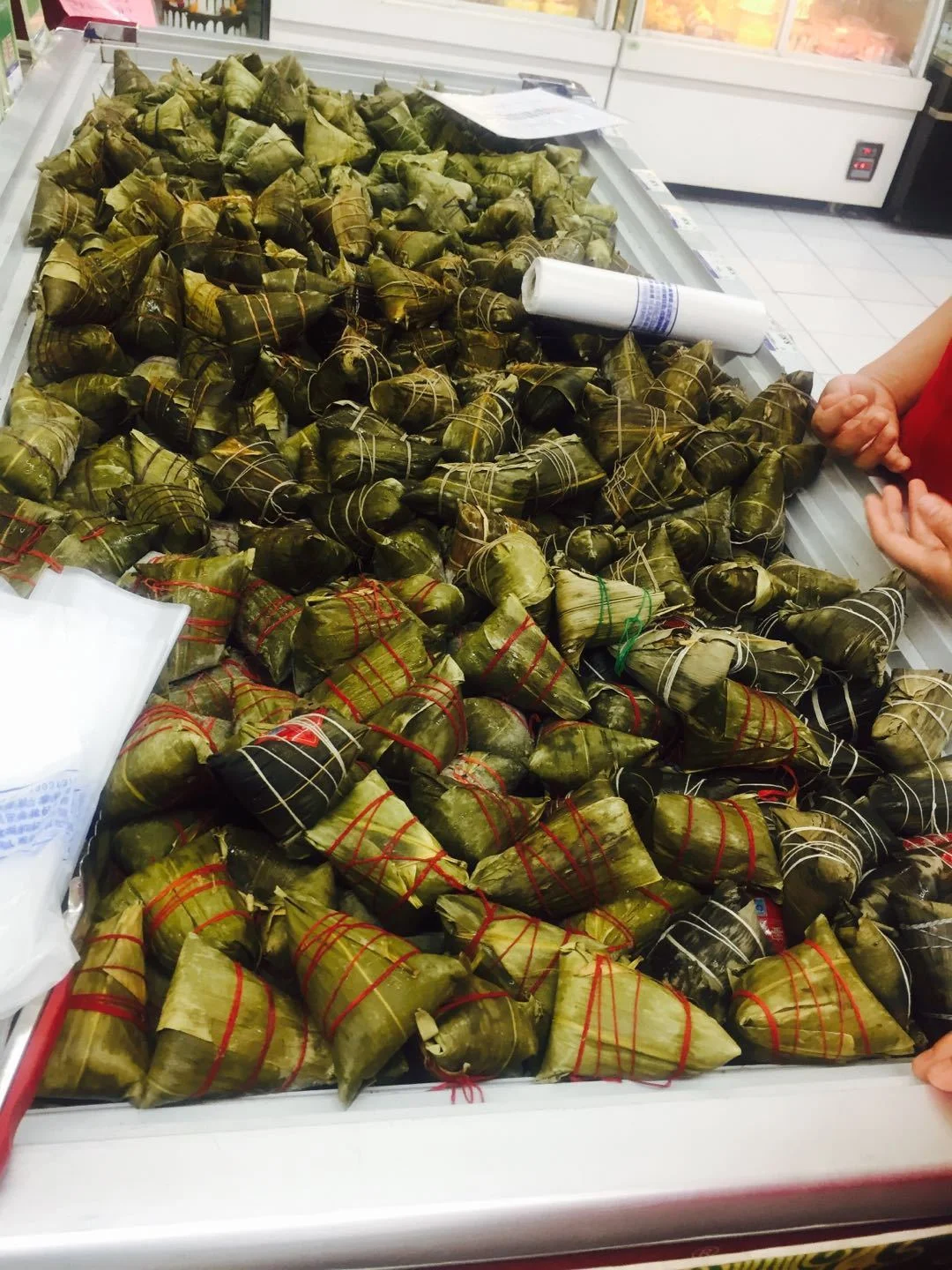 Wuhan Dragon Boat Festival atmosphere: traditional zongzi making or display, festive decorations with dragon boat motifs, and the lively energy of a city preparing for one of its oldest annual celebrations