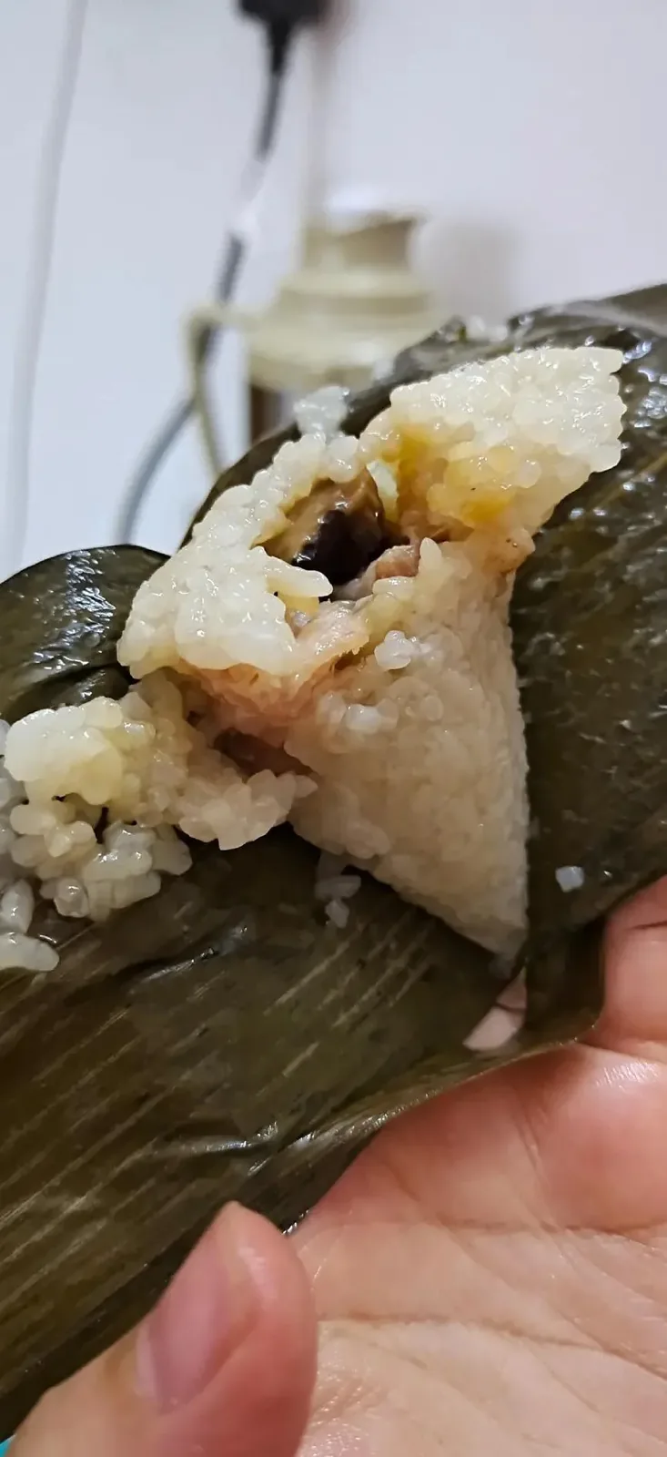 Homemade zongzi in various stages of preparation or consumption, showing the different styles and fillings that divide Wuhan families into fiercely loyal camps