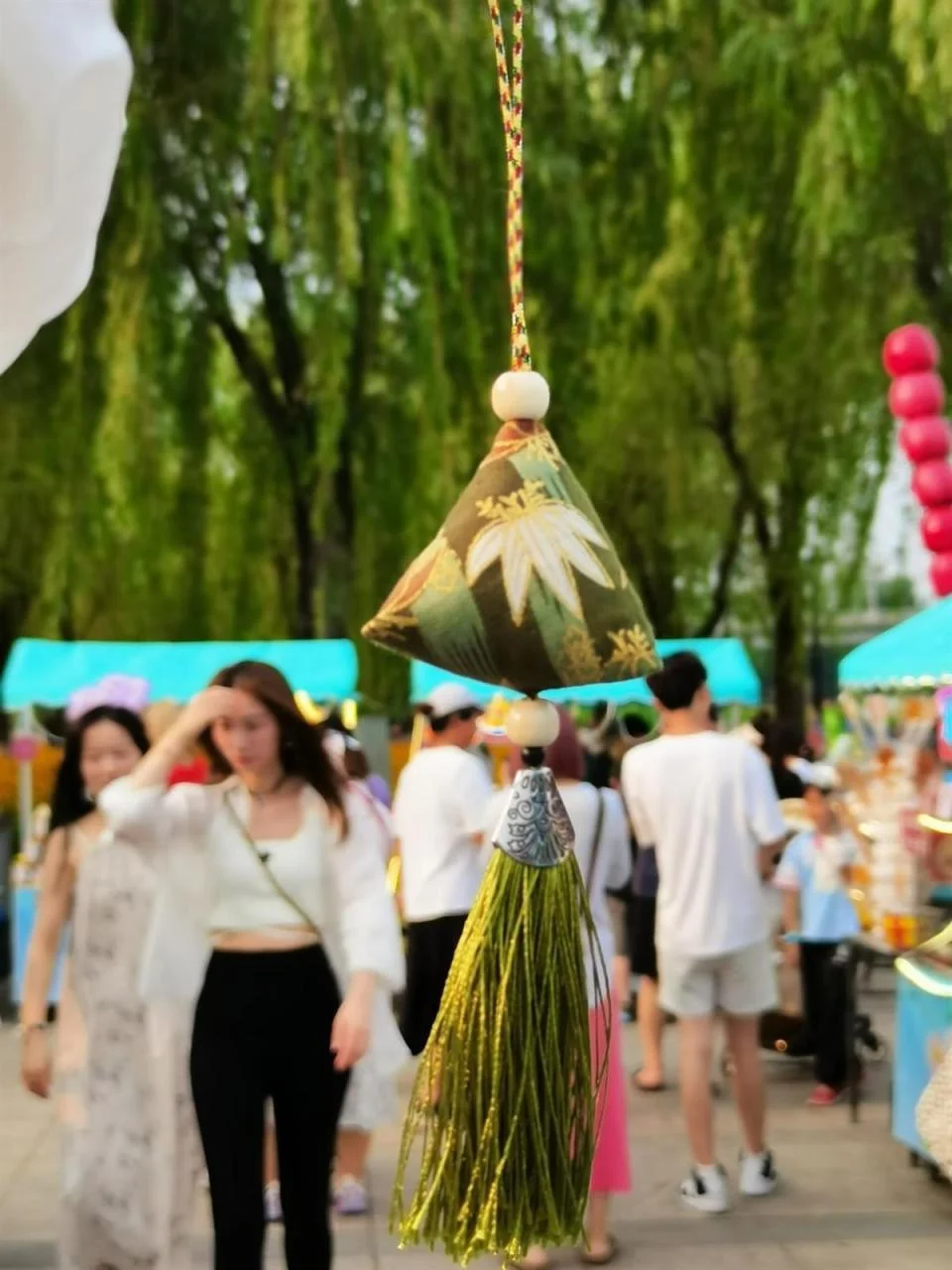 Wuhan riverside park scene where families gather during Dragon Boat Festival, enjoying food, watching races, and celebrating together in the warm June atmosphere