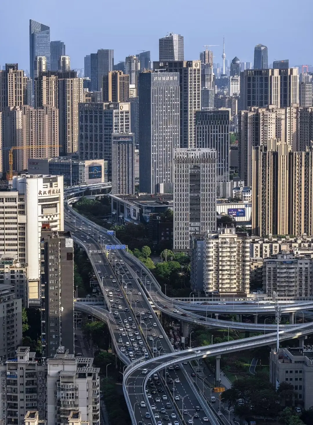 Driving view from a Wuhan elevated highway showing the road stretching ahead toward the city skyline, taken from driver's perspective 15 meters above ground