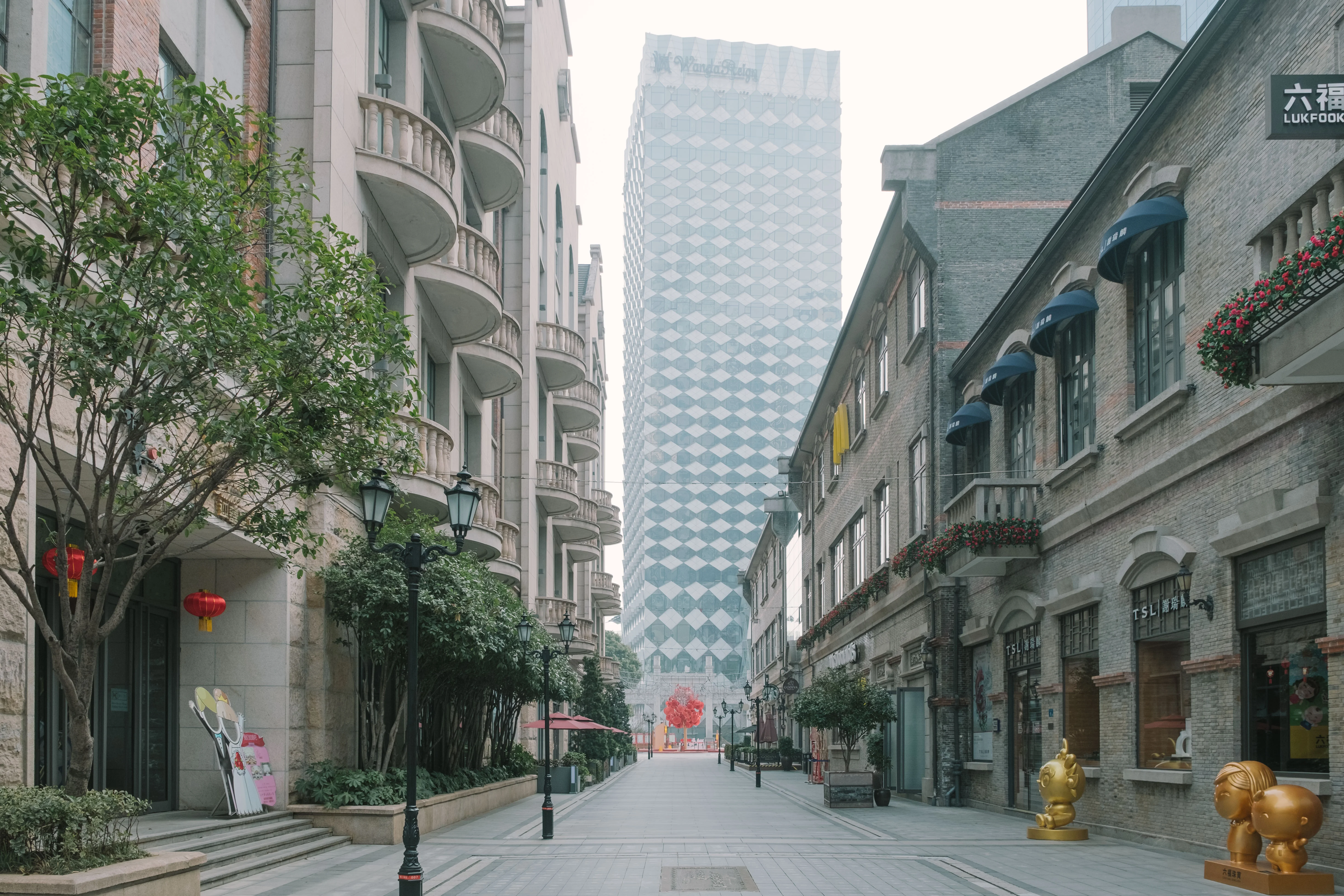 An empty multi-lane Wuhan avenue during Chinese New Year, normally packed with traffic, now with only a few cars and red lanterns hanging from streetlights