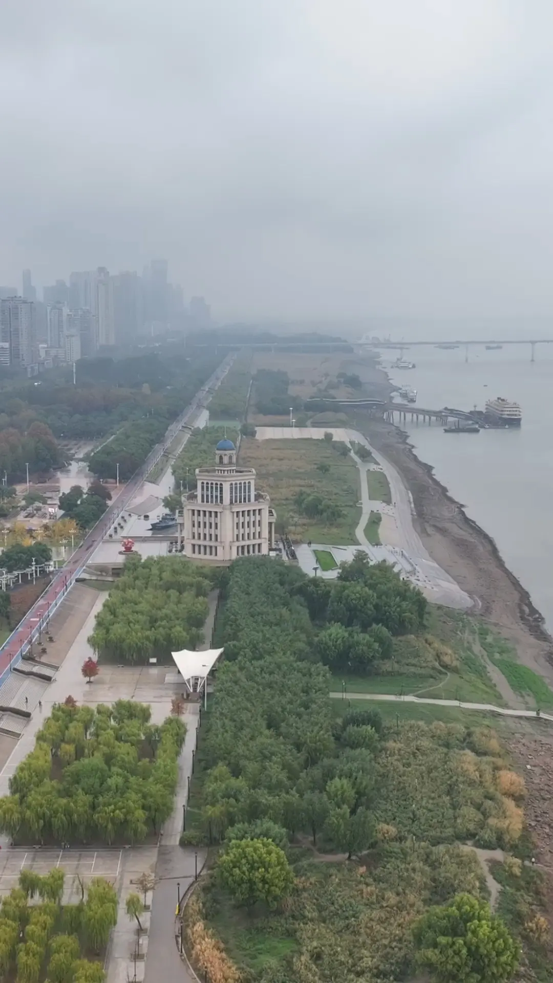 The Hankou riverfront park built on top of flood levees, with people walking along the promenade while the Yangtze flows at high water level