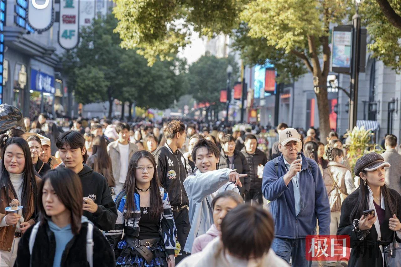 A street scene in Wuhan showing a mix of Chinese and foreign pedestrians, capturing the everyday diversity of the city where foreigners live and work