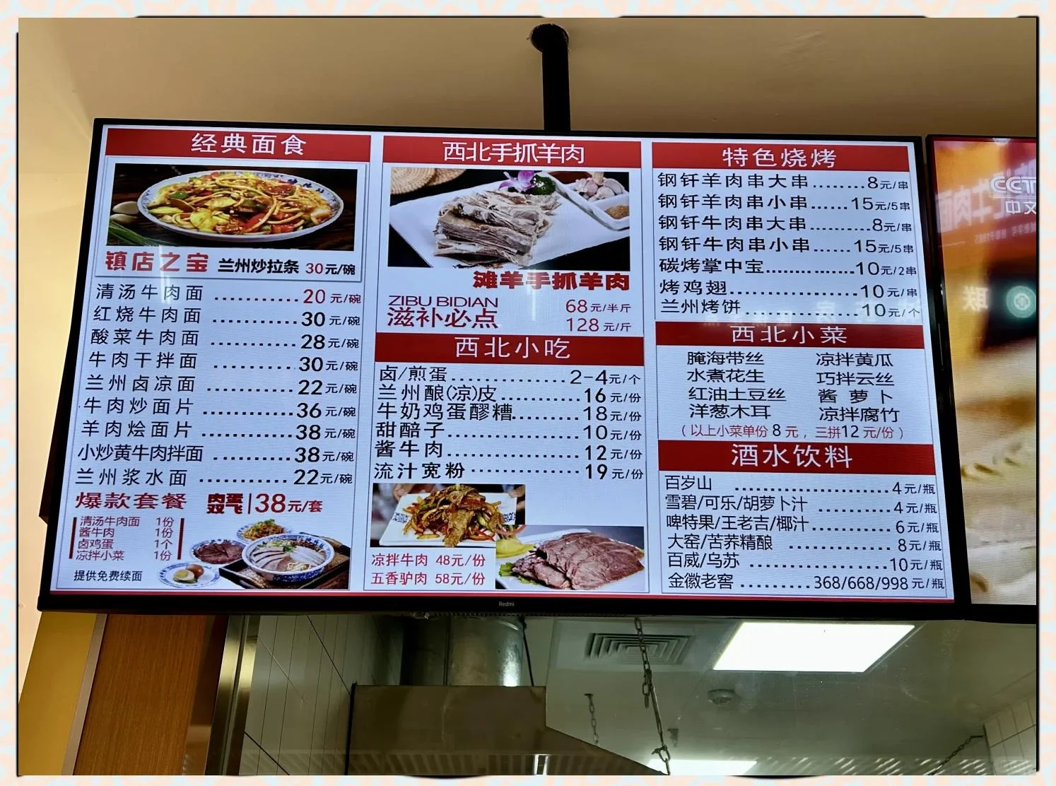 A backlit menu board in a halal restaurant listing beef noodle dishes from 20 to 38 yuan, northwest hand-grab lamb, lamb skewers, cold side dishes, and a drinks section including beer and baijiu