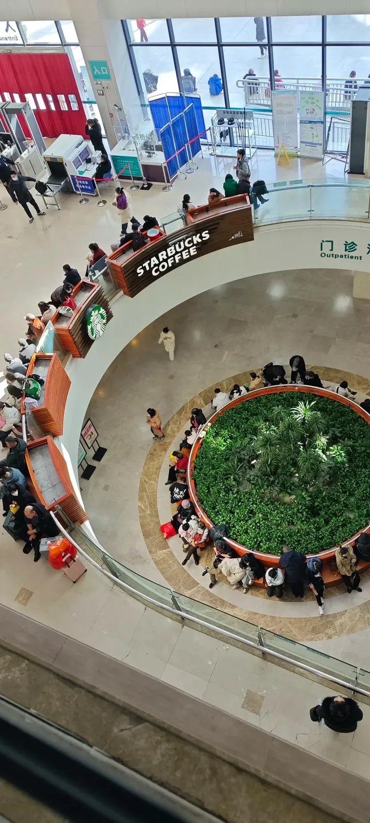 Interior of a Wuhan hospital showing the busy waiting area with patients and medical staff, capturing the scale of a typical Chinese hospital