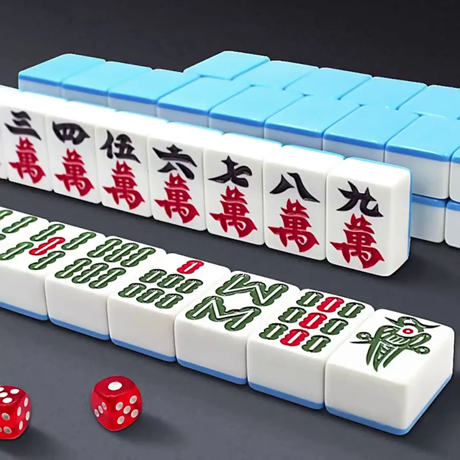 Close-up of Wuhan mahjong tiles spread on a green felt table surface with score chips scattered around