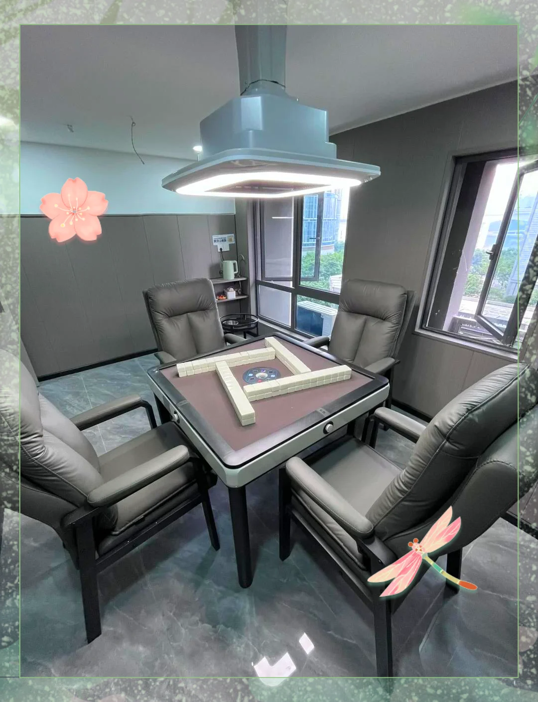 Wuhan living-room parlour with four players seated around a square mahjong table, tea cups and a water bottle visible