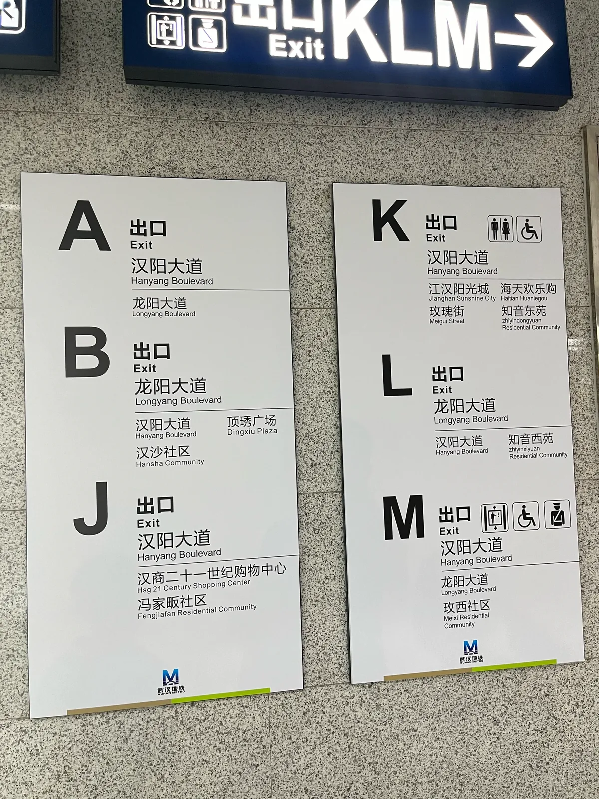 Wuhan Metro station exit sign board showing multiple exit options with Chinese and English labels, the kind that confuses newcomers