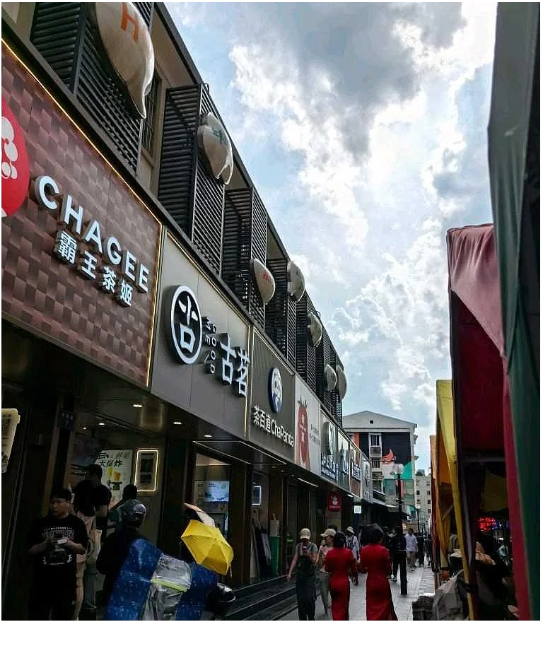 A row of milk tea shops along a busy Wuhan street, showing the density and variety of tea chains competing for customers