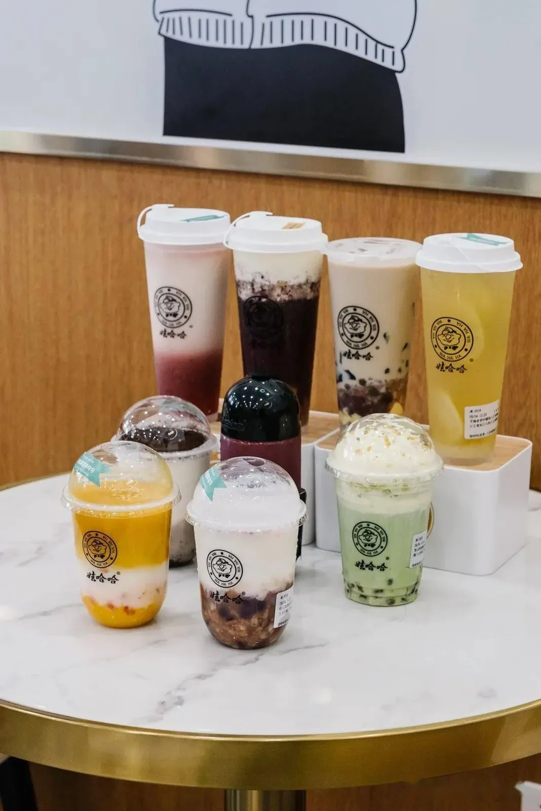 Collection of colorful milk tea cups from various Wuhan chains, showing the variety and signature designs of different tea brands