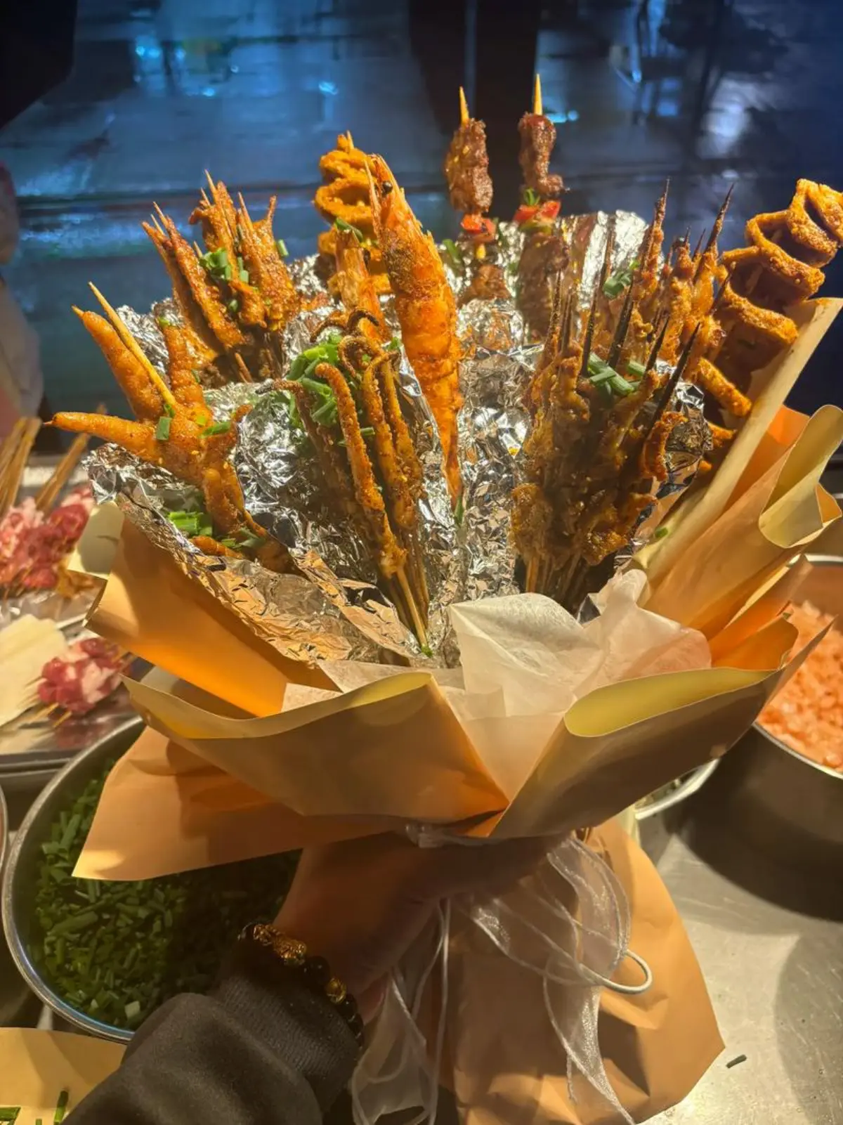 Young people dining at Wuhan night market — plastic tables, skewers, beer bottles, laughter