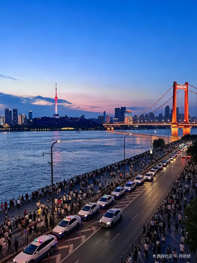 Hankou Bund blue hour with Jianghan Customs House lit up against deep blue sky and ferry light trails on the Yangtze