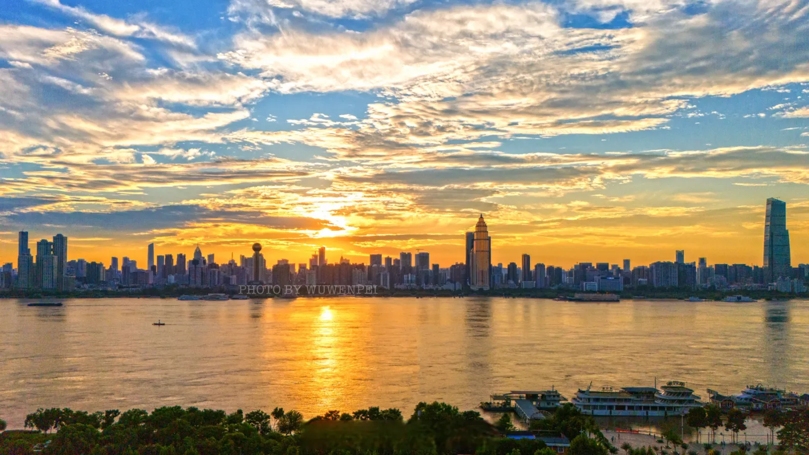 Wuhan skyline at sunset with Yangtze Bridge silhouette and city lights from a photographer's vantage point