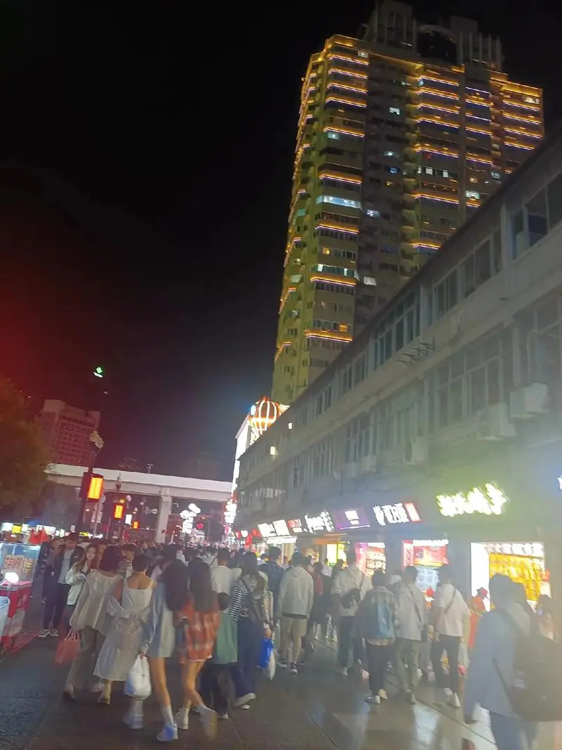 Wuhan old street at night after 10 PM, street food stalls, motorcycles and neon signs showing the raw energy of the city