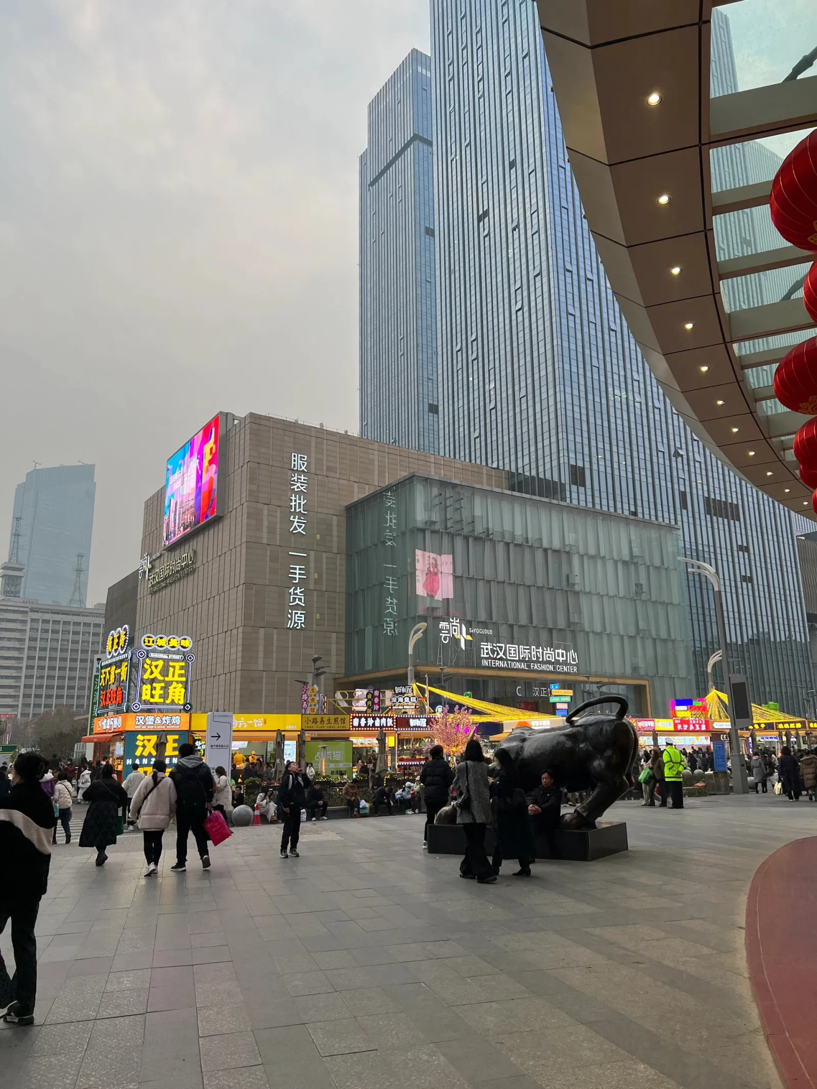 Wuhan shopping street at night with neon signs, crowds of shoppers, and storefronts lit up after dark