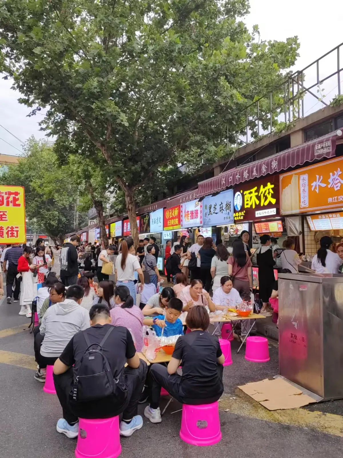 Handwritten breakfast stall menu board in Wuhan showing Chinese dish names and prices for reganmian, doupi, and mianwo