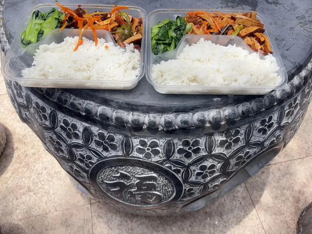 Buddhist vegetarian food at Guiyuan Temple canteen in Wuhan showing lotus root and tofu dishes on metal trays