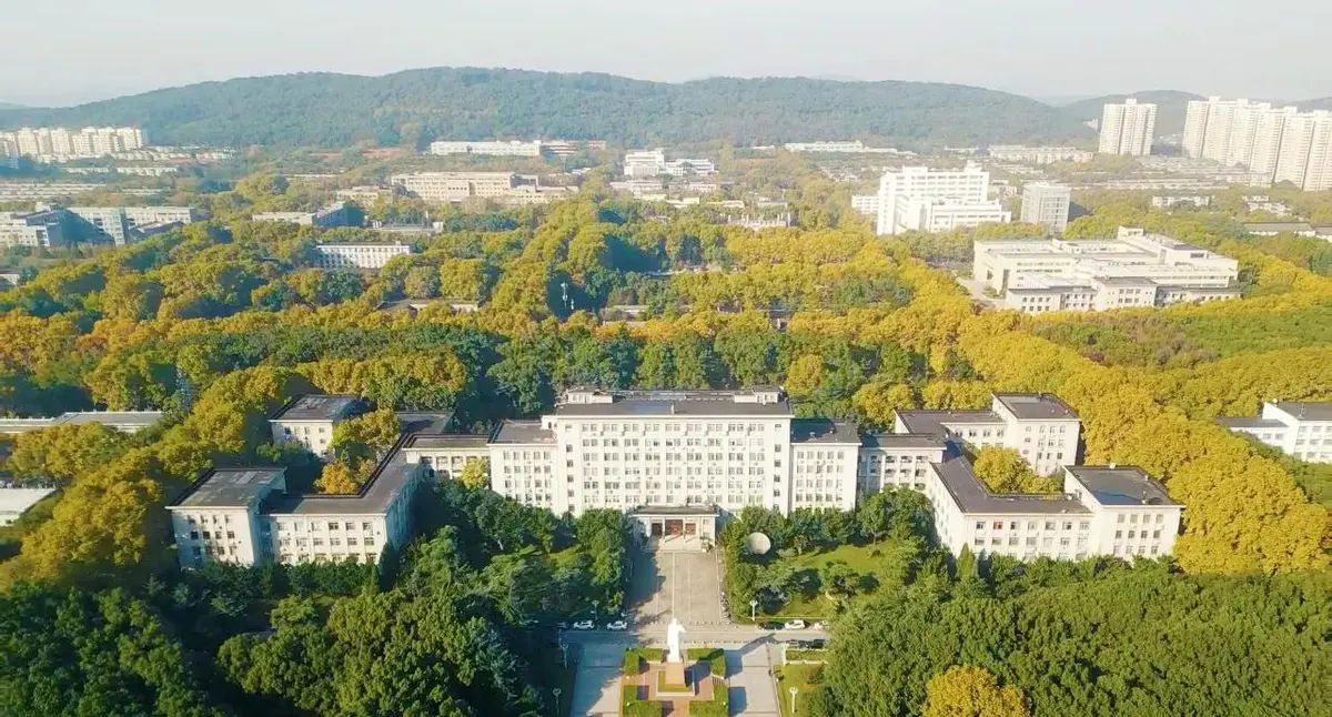 Huazhong University of Science and Technology campus in Wuhan, showing the main teaching building and students walking between classes