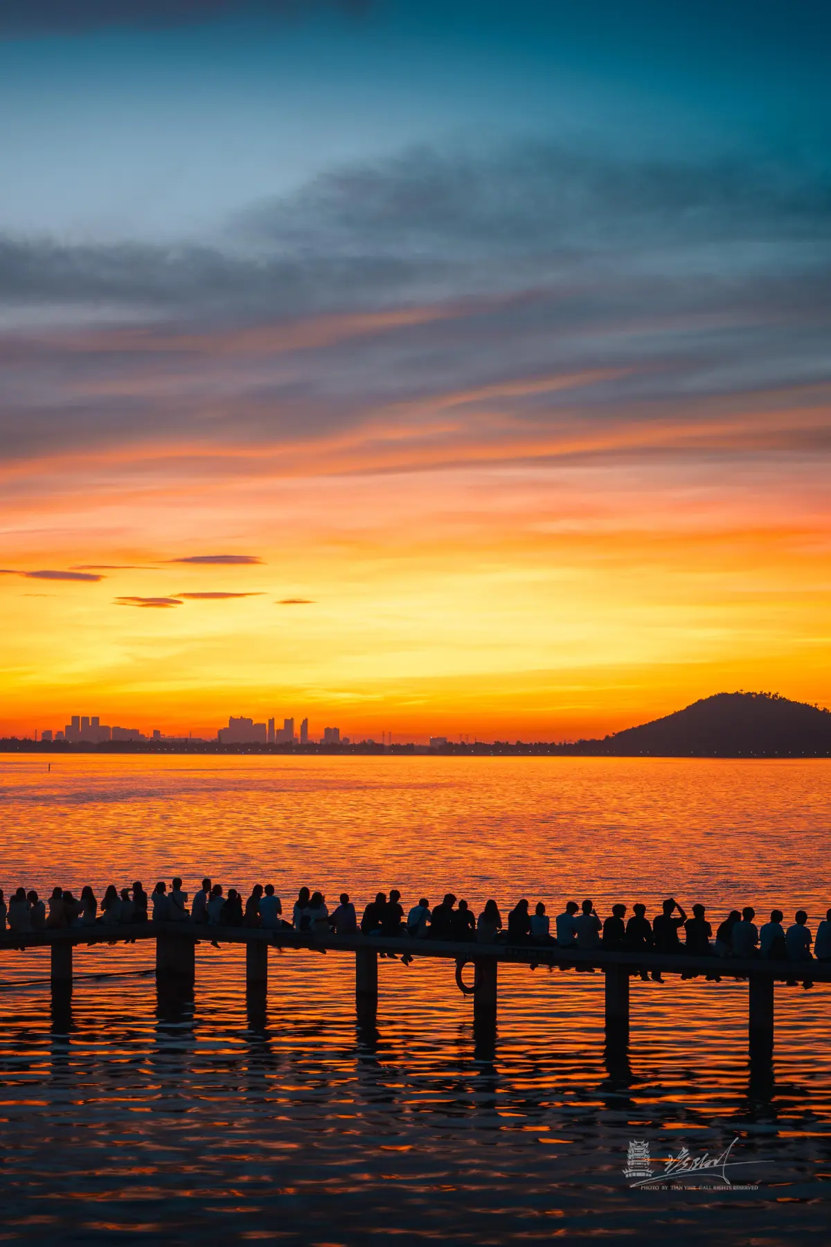 View of East Lake from Wuhan University campus at golden hour, lake and city skyline in the distance