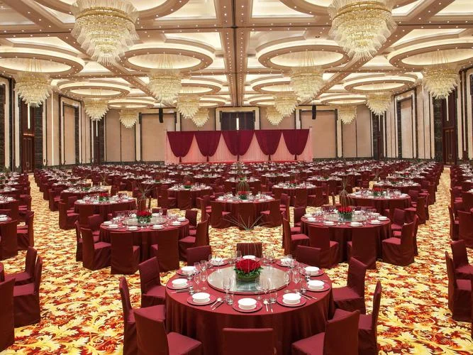 A traditional to modern Wuhan wedding banquet hall: red everywhere, gold characters on the walls, a stage with the couple being toasted by a crowd of guests, the combination of ceremonial excess and genuine joy that defines wedding celebrations in central China