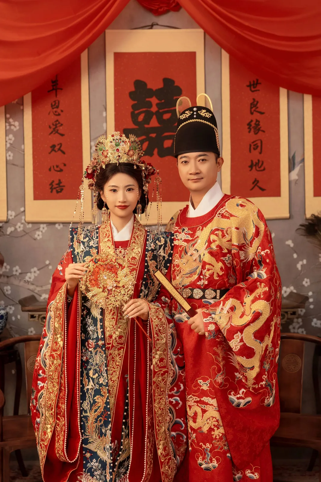 A beautiful pre-wedding portrait of a Wuhan couple in traditional Chinese wedding dress: red silk, gold embroidery, formal poses capturing the blend of ancient symbolism and modern romance, often taken in studios with elaborate backdrops