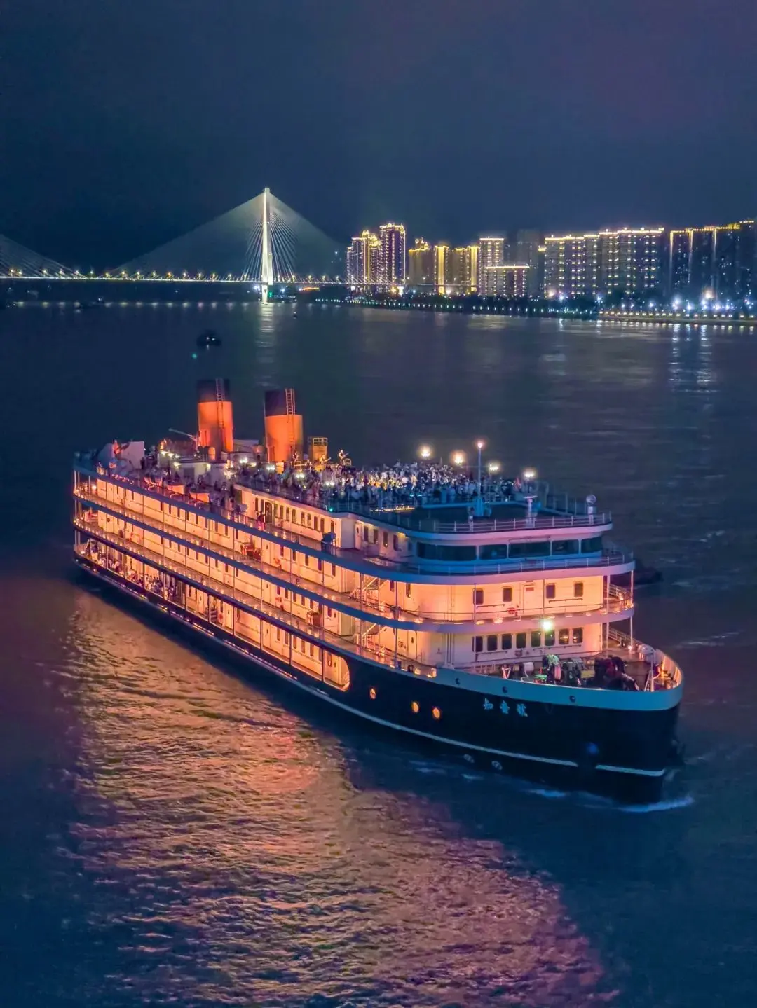 Wuhan Yangtze River at night with the two-river four-bank light show illuminating buildings along the waterfront